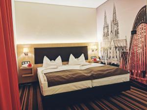 a bedroom with a large bed in a room at Hotel Fortune in Cologne