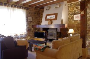 ein Wohnzimmer mit einem Sofa und einem Kamin in der Unterkunft El Rincón del Besaya in Villasuso de Cieza
