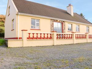 une maison avec une clôture devant elle dans l'établissement Upper Haven, à Eyeries