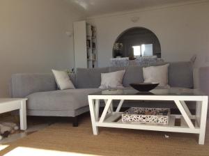 a living room with a couch and a table at Beach front/waterside apartment in Luz