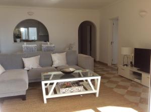 a living room with a couch and a coffee table at Beach front/waterside apartment in Luz