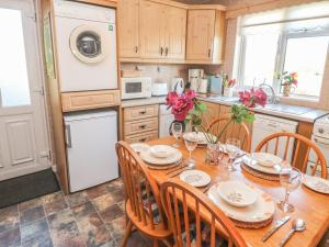 Kate's Cottage في جزيرة فالينتيا: مطبخ مع طاولة خشبية مع كراسي وغرفة طعام