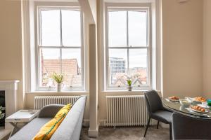 a living room with a couch and a table and windows at Newly Converted Apartment Rowntree House Shambles in York