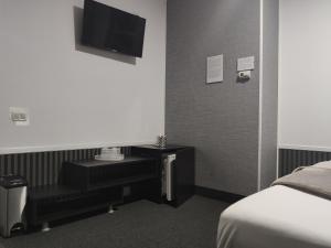 a hotel room with a bed and a desk and a tv at Hello Villa in Bucharest