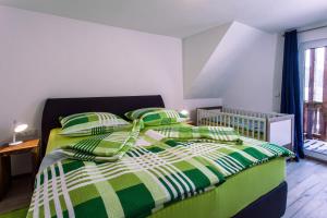 1 dormitorio con 1 cama con edredón verde y blanco en Ferienwohnungen Schwabenhof en Schramberg