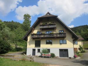 ein großes gelbes Haus mit einem Gameradach in der Unterkunft Ferienwohnungen Schwabenhof in Schramberg