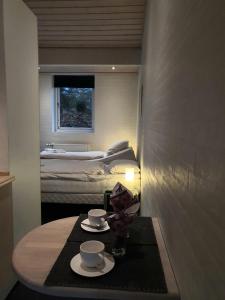 Una habitación con una mesa con dos tazas y una cama en Bente's Guesthouse, en Holstebro