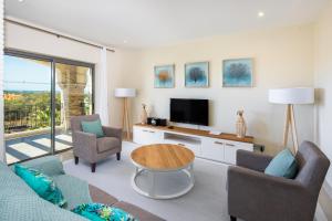 a living room with a couch and a tv at Shantiapartments in Vilamoura