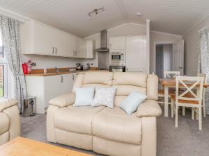 a living room with a couch and a kitchen at Duckling Lodge in Carnforth