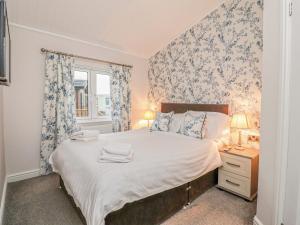 um quarto com uma cama grande e uma janela em Duckling Lodge em Carnforth