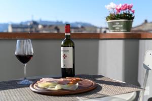 a bottle of wine and a plate of food and a glass at B&B The Attico in Florence