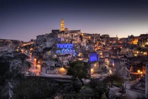 a view of a city at night at L'Affaccio Dell'Abate in Matera