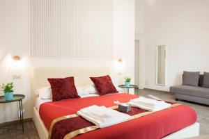 una camera da letto con un letto rosso e asciugamani di B&B Martucci Avenue a Napoli
