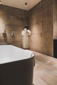 un bagno con vasca e una persona sullo sfondo di Waer Waters Spa Hotel a Groot-Bijgaarden