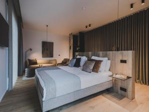 a bedroom with a large bed and a couch at Waer Waters Spa Hotel in Groot-Bijgaarden