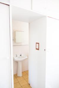 Baño blanco con lavabo y espejo en Green Nook en Plettenberg Bay
