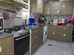 a kitchen with a stove and a washing machine at Bed Space For Females Near Metro Station in Dubai