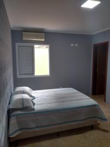 Un dormitorio con una cama con ventana. en Casa de praia Peruibe, en Peruíbe 21 fotos más