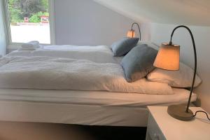 a bedroom with a bed with two lamps on it at Moldegaard Riding Lodge in Moldegard