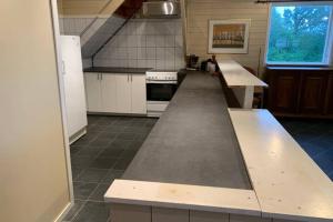 uma cozinha com um balcão longo no meio em Moldegaard Riding Lodge em Moldegard