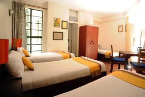 Kenya Comfort Hotel tesisinde bir odada yatak veya yataklar