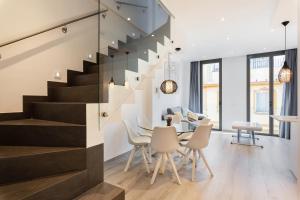 a dining room and kitchen with a staircase and a table and chairs at Minty Stay - La Merced Atico Duplex in Málaga