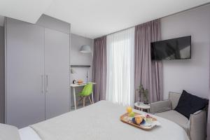 a hotel room with a bed with a tray of food on it at VISIONAPARTMENTS Neustadtstrasse - contactless check-in in Lucerne