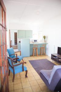 a living room with a couch and a kitchen at Green Nook in Plettenberg Bay