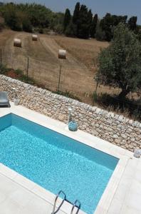 una piscina di fronte a un muro di pietra di Villa Sea Sky - Sicily In a Pozzallo