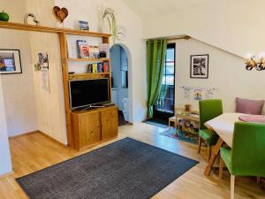 salon z telewizorem, stołem i krzesłami w obiekcie Appartement Azalea Oetz w mieście Oetz