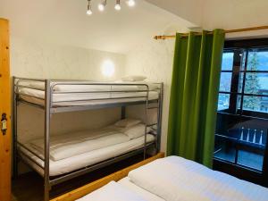 Pokój z łóżkiem piętrowym i zieloną zasłoną w obiekcie Appartement Azalea Oetz w mieście Oetz