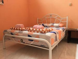 Una cama con manta y almohadas. en Homestay Abdul, en Kampung Banggul Gucil
