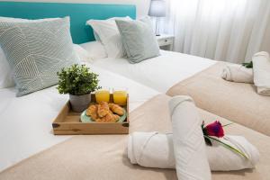 two beds with a tray of food and glasses of orange juice at Amarre Fuente in Puerto de Mogán