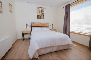 Un dormitorio con una cama grande y una ventana en Huellas y Senderos Hotel, en Coyhaique