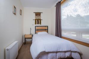 a bedroom with a bed and a large window at Huellas y Senderos Hotel in Coihaique