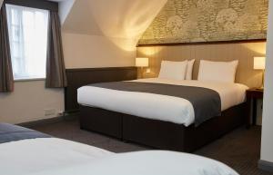a hotel room with a bed and two lamps at Ravensworth Arms by Chef & Brewer Collection in Gateshead
