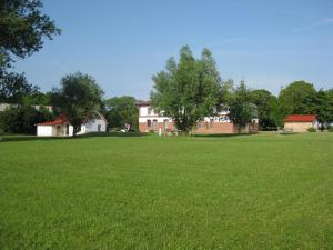 un gran campo de césped verde con una casa en el fondo en Ferienwohnungen Ostseestern, en Rakow