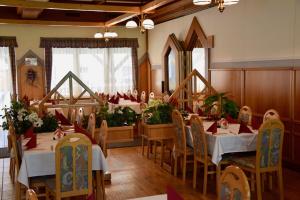 a restaurant with tables and chairs with flowers on them at Gasthof Kasperle in Spittal an der Drau