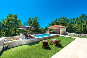 a backyard with a pool and a table and chairs at Villa Novak in Čilipi