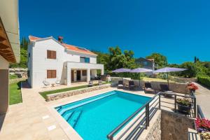 uma villa com uma piscina e uma casa em Villa Novak em Cilipi