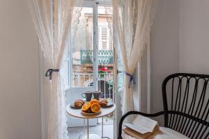 a table with a plate of donuts on it next to a window at Giudecca Apartments in Syracuse