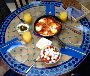 a table with a plate of food and glasses of orange juice at Artist Quarter Guesthouse B&B in Safed