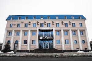 un grand bâtiment blanc avec un toit bleu dans l'établissement Mirage Hotel, à Saratov