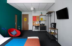 a bedroom with a bed and a red chair at The Social Hub Rotterdam in Rotterdam