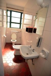 een badkamer met een wastafel, een toilet en een spiegel bij Kenya Comfort Hotel in Nairobi