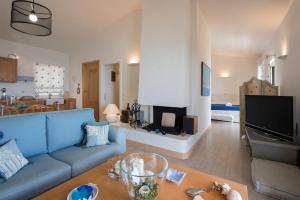 un salon avec un canapé bleu et une télévision dans l'établissement Lavender House (Glyfada beach), à Glyfada