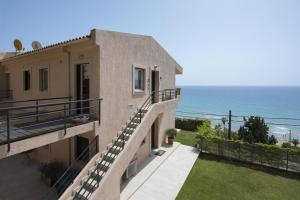 une maison avec un balcon avec vue sur l'océan dans l'établissement Lavender House (Glyfada beach), à Glyfada