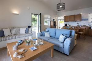 un salon avec un canapé bleu et une table dans l'établissement Lavender House (Glyfada beach), à Glyfada