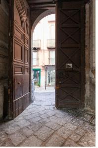 una porta aperta in legno in un edificio con strada di La Casa di Nina a Napoli