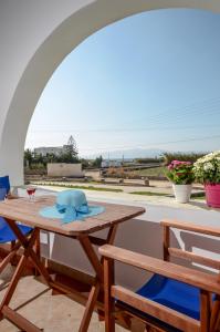 een tafel met een blauwe hoed op een patio bij Gaitani apartments plaka naxos in Mikri Vigla